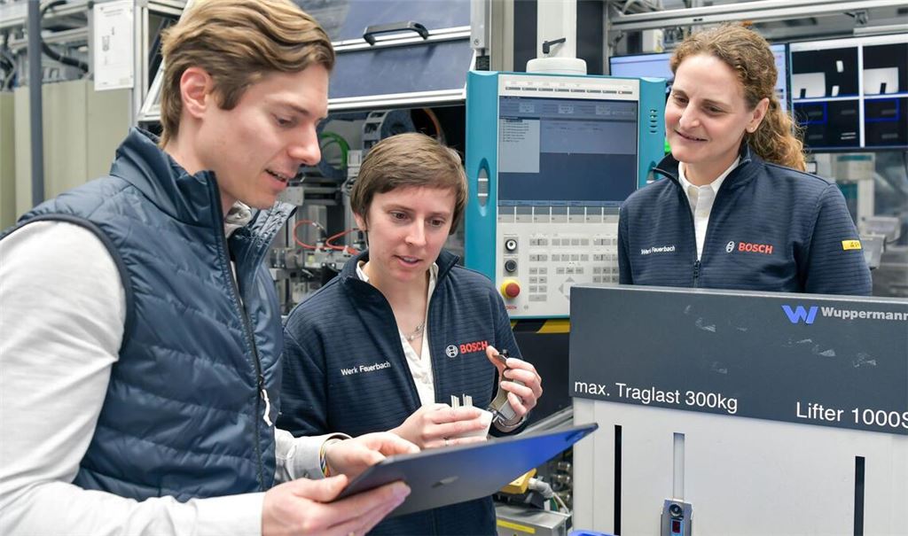 Philipp Glaser, Elisabeth Schwarz und Larissa Bauer zeigen bei einem Rundgang durch einen Teil der Fertigung bei Bosch in Feuerbach, wie das Zusammenspiel zwischen Mensch und KI-Agent funktioniert.