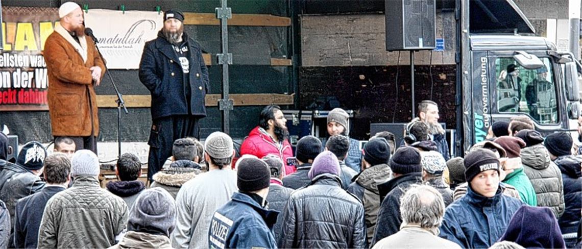 Pierre Vogel (li.) redet vor 200 Zuhörern. Starke Polizeikräfte müssen die Kundgebung schützen. Abgesehen von einem Pfeifkonzert bleibt alles ruhig. Foto: Mummert