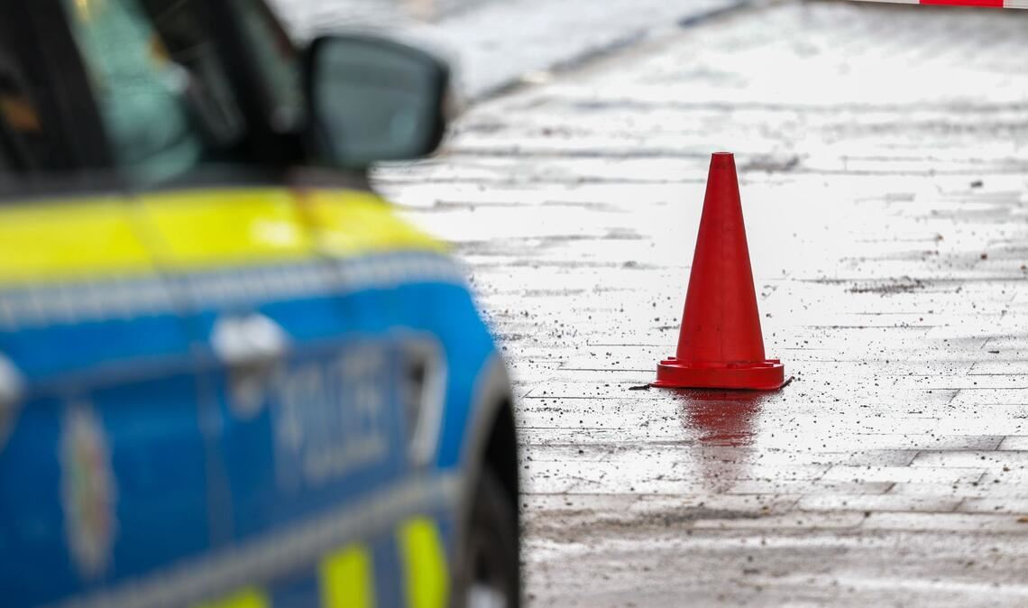 Polizeibeamte bewachen in einem Streifenwagen den Tatort.