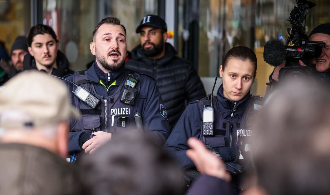 Polizeibeamte sprechen mit möglicherweise betroffenen Kunden der Sparkassenfiliale in Buer.