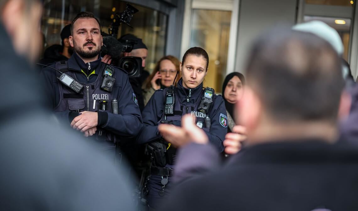 Polizeibeamte sprechen mit möglicherweise betroffenen Kunden der Sparkassenfiliale in Buer.