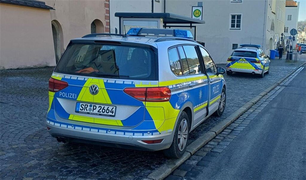 Polizeifahrzeuge stehen auf der Straße. Nach der Flucht eines Verdächtigen bei der Vorführung im Amtsgericht sucht die Polizei in Passau mit einem Großaufgebot nach dem Mann.