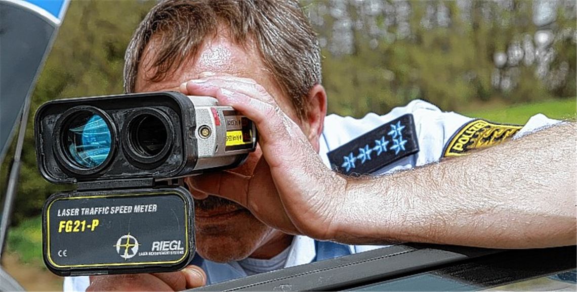 Polizeihauptmeister Rainer Hampel liegt mit einem Handlasermessgerät auf der Lauer, um etwaige Temposünder zu erwischen. Fotos: Sadler
