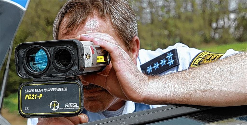 Polizeihauptmeister Rainer Hampel liegt mit einem Handlasermessgerät auf der Lauer, um etwaige Temposünder zu erwischen. Fotos: Sadler