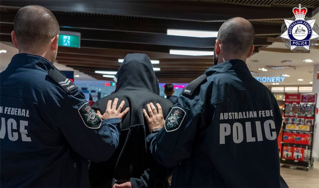 Polizisten führen den Schmuggler ab.