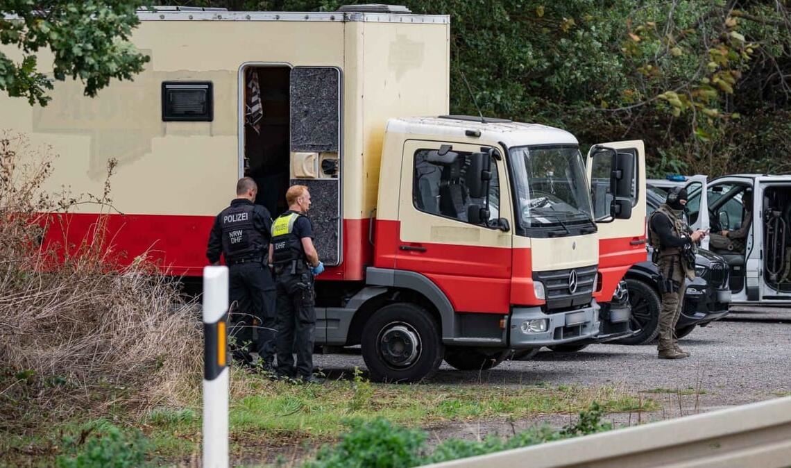 Polizisten in Spezialausrüstung sind an einem Lkw im Einsatz. Die Polizei hat laut NRW-Innenminister Reul in Niederzier das Fahrzeug des Verdächtigen für mehrere Sabotageaktionen gegen die deutsche Stromversorgung gestürmt.