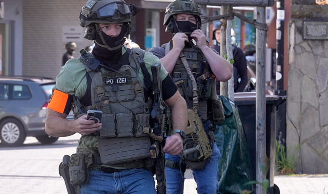 Polizisten mit Spezialausrüstung sind in Sinzig im Kreis Ahrweiler bei einer Geiselnahme im Einsatz.