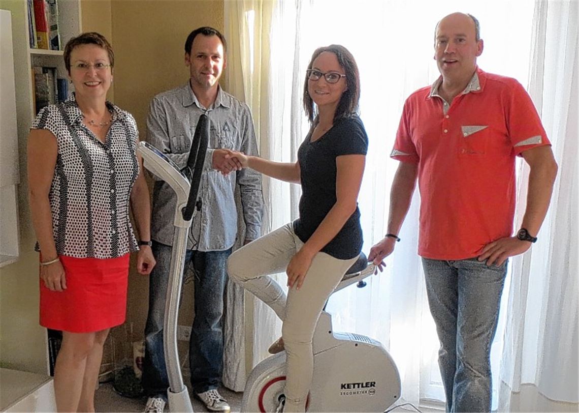 Präsident Marco Bogner und Past-Präsidentin Gabi Nonnenmacher sowie ein Mitarbeiter der Firma Intersport Elsässer mit Kim Schwemmle bei der Übergabe des Ergometers.