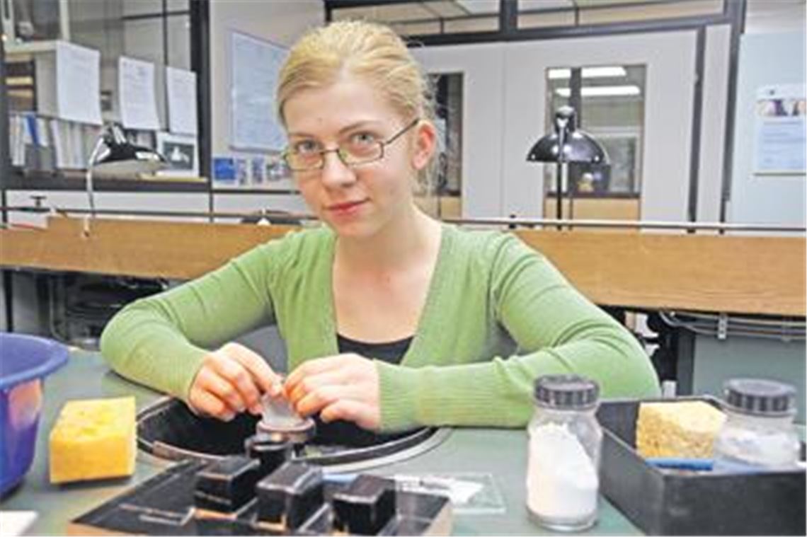 Präzisionsarbeit: Feinoptikern Anja Gröhbühl, die ihre Ausbildung als Landesbeste abgeschlossen hat, schleift und poliert in der Lehrwerkstatt von Richard Wolf ein Prisma bis auf ein viertausendstel Millimeter genau. Foto: Hansen