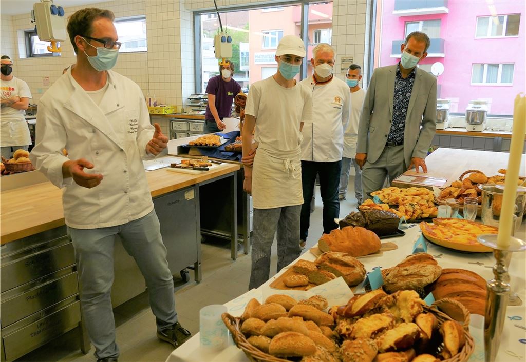 Praktische Prüfung der Bäcker in der Alfons-Kern-Schule: Prüfer Ralf Jäkle, Azubi Jakob Heckmann mit seiner Präsentation, Obermeister Martin Reinhardt und Landrat Bastian Rosenau (v.li.).Peche