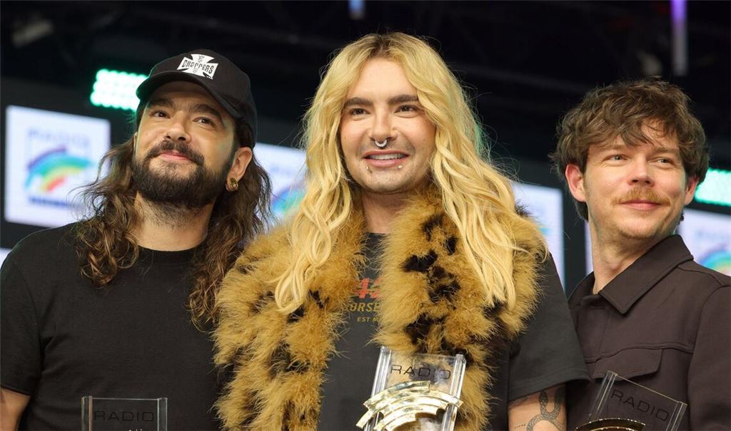 Preisträger Tom Kaulitz, Bill Kaulitz und Georg Listing von Tokio Hotel auf der Bühne der Preisverleihung (von links).