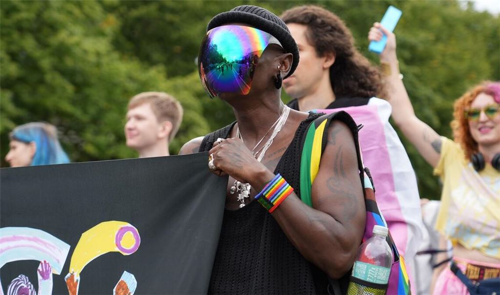 Pride-Demo: Ein Teilnehmer trägt ein bunt schillerndes Visier bei einer Demonstration in Berlin unter dem Motto: "Inta* Pride Berlin 2025 - we exist!".