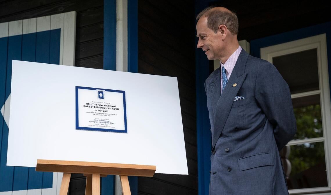 Prinz Edward schaut sich die Ehrenplakette am Alexander Haus in Groß Glienicke an.