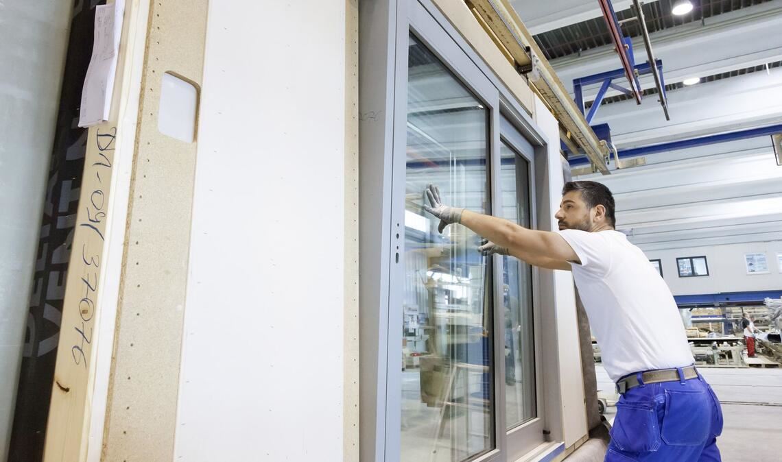 Produktion bei Schwörer Haus in Oberstetten: Bei der Hauswand  werden  Fenster eingebaut.