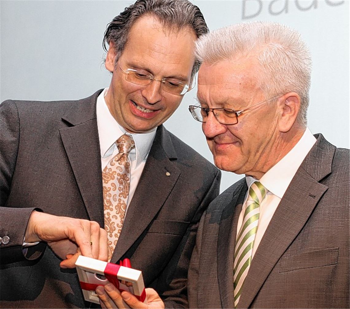 Professor Dr. Martin Erhardt, Rektor der Hochschule Pforzheim (li.), übergibt an Ministerpräsident Winfried Kretschmann die Gedenkmünze der Fakultät.