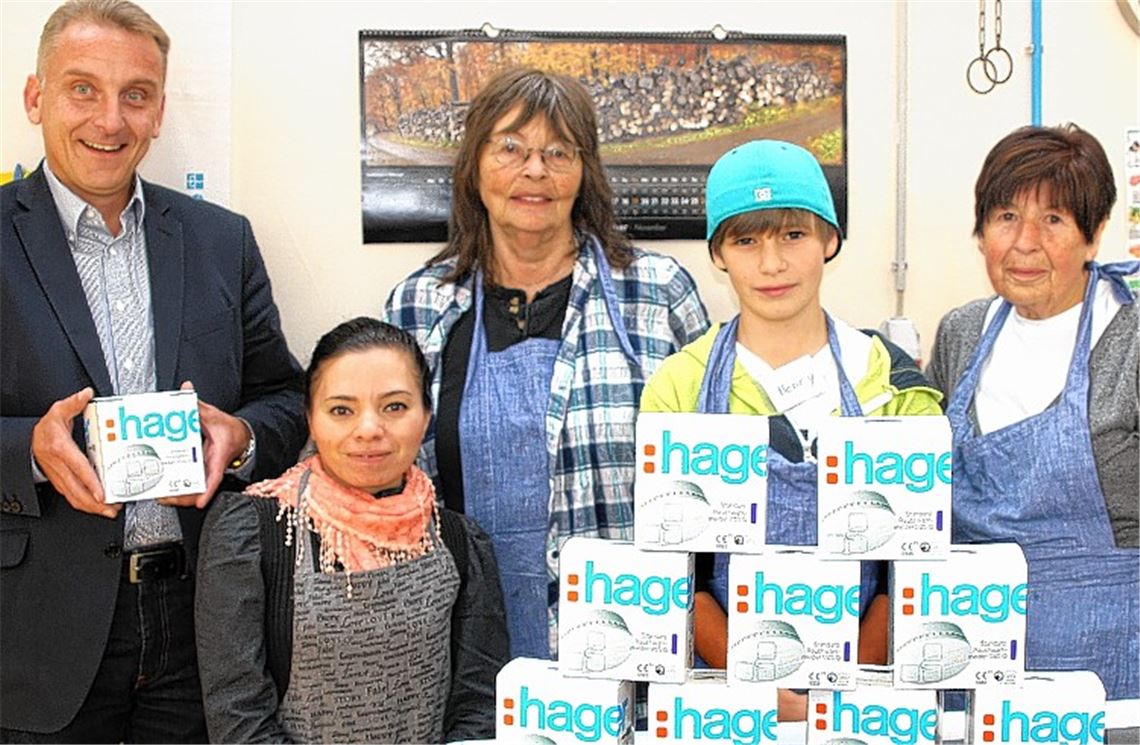 Prokurist Matthias Bosch übergibt die Rauchmelder an die Leiterin des Tafelladens, Erika van Luijk (3. v. li.), und ihr Team.