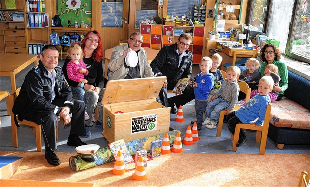 Raimund Bauer (li.), Gerhard Ott (Mitte) und Peter Weber (rechts von ihm) übergeben eine Verkehrsspielkiste an den städtischen Kindergarten „Pusteblume“ in Enzberg. Foto: Fotomoment