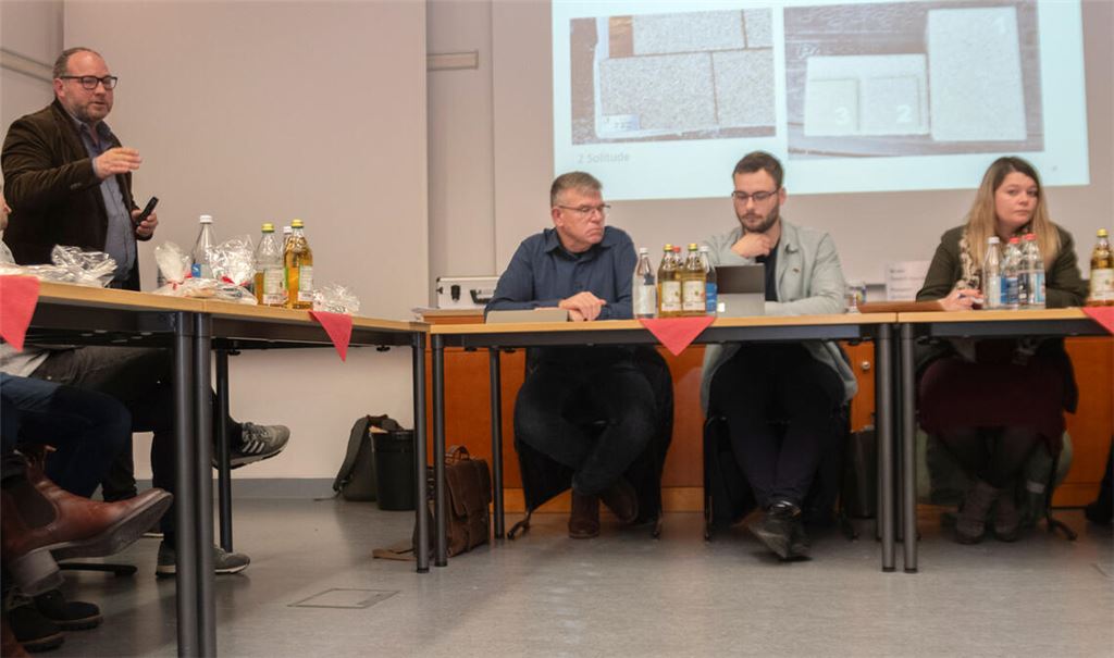 Ralf Duffner (hinten li.) stellt die Entwurfsplanung und mögliche Pflastersteine für die Ortsmitte vor. Foto: Fotomoment