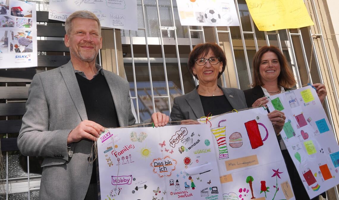 Junge Menschen aus der Armut holen Ralf Nuglisch vom Paritätischen Wohlfahrtsverband, Staatssekretärin Ute Leidig und Katharina Meyer vom Pforzheimer Bildungsträger „Q-Prints and Service“ (v. li.) zeigen Plakate, die im Rahmen des „Silky“-Projekts entstanden sind. Foto: Roller