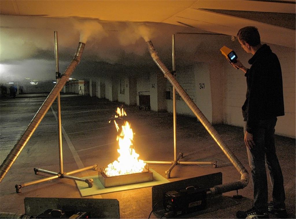 Rauchschwaden durchziehen das dritte Untergeschoss der Tiefgarage, und ein Mitarbeiter des Fraunhoferinstuts misst die Wärmeentwicklung in der Tiefgarage. Fotos: Appich