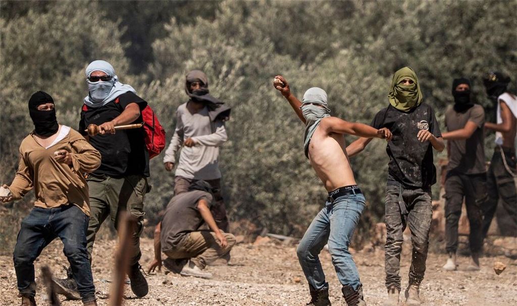 Rechtsgerichtete israelische Siedler werfen Steine auf palästinensische Dorfbewohner (Archivbild).