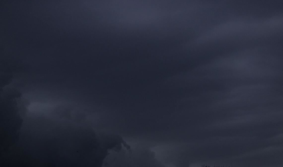 Regenwolken sind am Abendhimmel über einem Haus in Köln zu sehen.