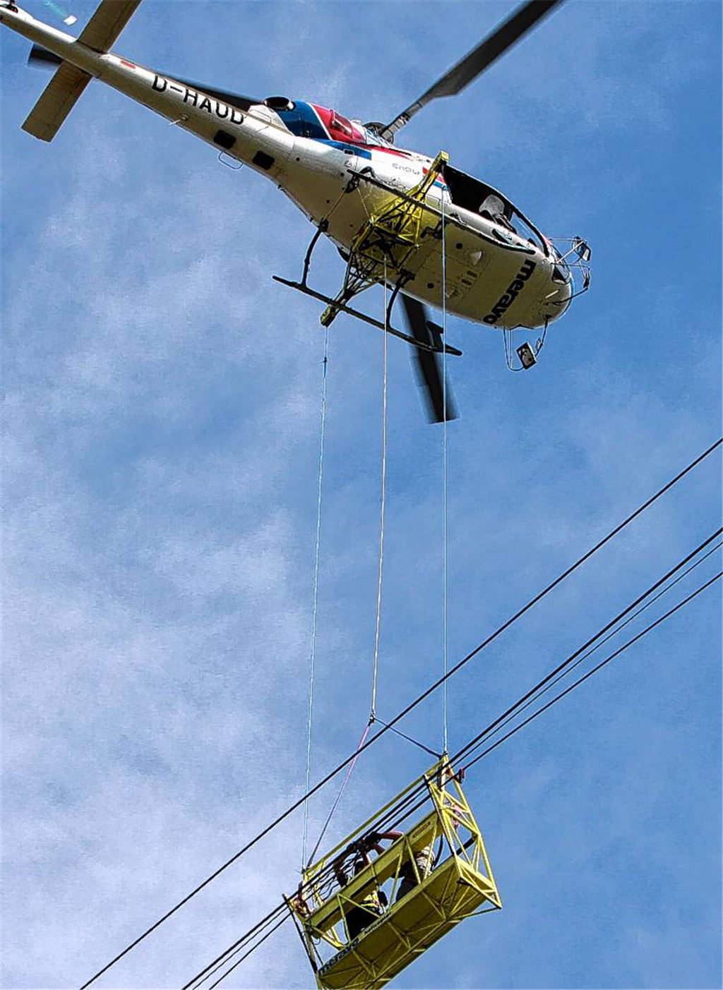Reine Routine? Die Monteure hängen in 60 Meter Höhe unter dem Hubschrauber.