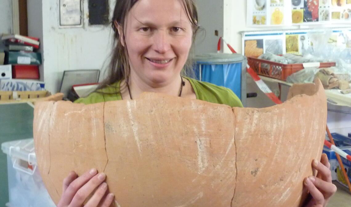 Restauratorin Bettina Bombach-Heidbrink zeigt ein Beispiel für historische Fundstücke im Zuge von Neubauprojekten in Mühlacker: eine römische Amphore, deren Bruchstücke auf der Baustelle für den denn’s-Biomarkt an der Goethestraße entdeckt wurden. Foto: privat