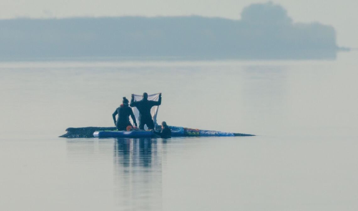 Retter sind am Morgen in der Nähe des Buckelwal vor der Insel Poel und legen Tücher auf dem Walrücken aus.