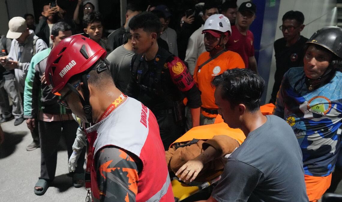 Retter tragen eine Frau auf einer Trage.