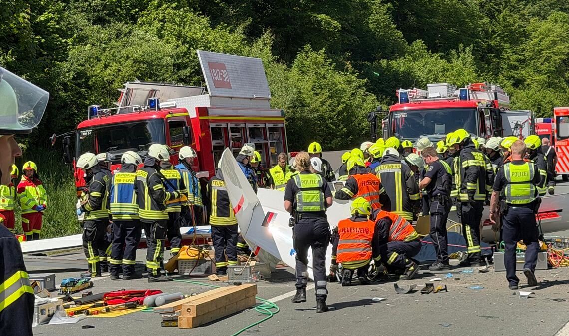 Rettungsdienste und Polizei arbeiten an der Unfallstelle, nachdem ein Segelflugzeug auf die A45 gestürzt ist.