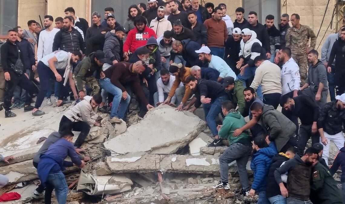 Rettungskräfte und Anwohner suchen nach Überlebenden in den Trümmern eines eingestürzten Gebäudes.