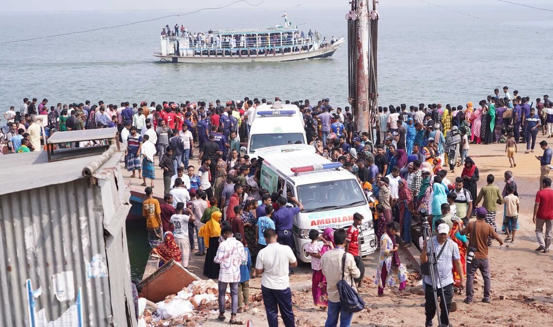 Rettungskräfte und zahlreiche Menschen versammeln sich an einer Unfallstelle, nachdem ein Bus in den Fluss Padma stürzte.