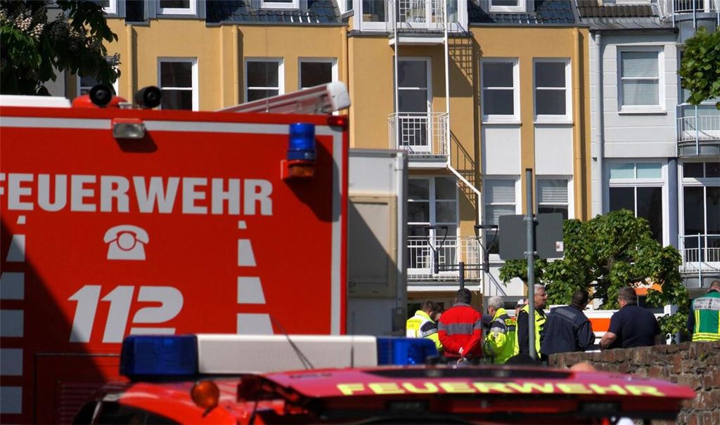Rettungswagen, Polizisten und Polizeifahrzeuge stehen in der Nähe des Einsatzortes.
