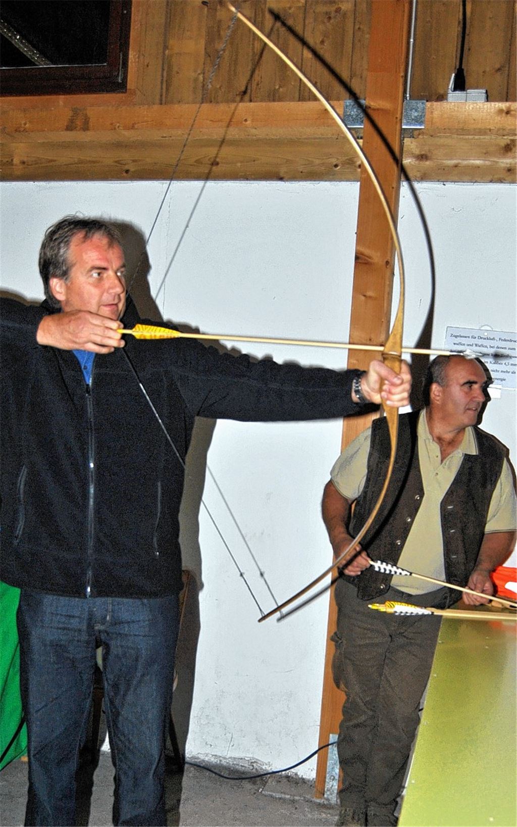 „Robin Hopp“ treffsicher: Knittlingens Bürgermeister Heinz-Peter Hopp versucht sich beim Knittlinger Schützenfest mit Erfolg an der neuen Trendsportart beim VfS, dem Bogenschießen, assistiert von Oberschützenmeister Bruno Wilhelm. Foto: Haller