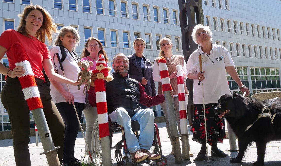 Rot-weiße Mützen für Poller helfen Sehbehinderten Rot-weiße Mützen für die Poller, damit sie für Menschen mit eingeschränktem Augenlicht besser erkennbar sind: Vertreterinnen und Vertreter des Enzkreises, der Stadt Pforzheim und des Badischen Blinden- und Sehbehindertenvereins schärfen mit einer Aktion am Landratsamt das Bewusstsein für die Bedürfnisse von Sehbehinderten. Foto: Friedrich