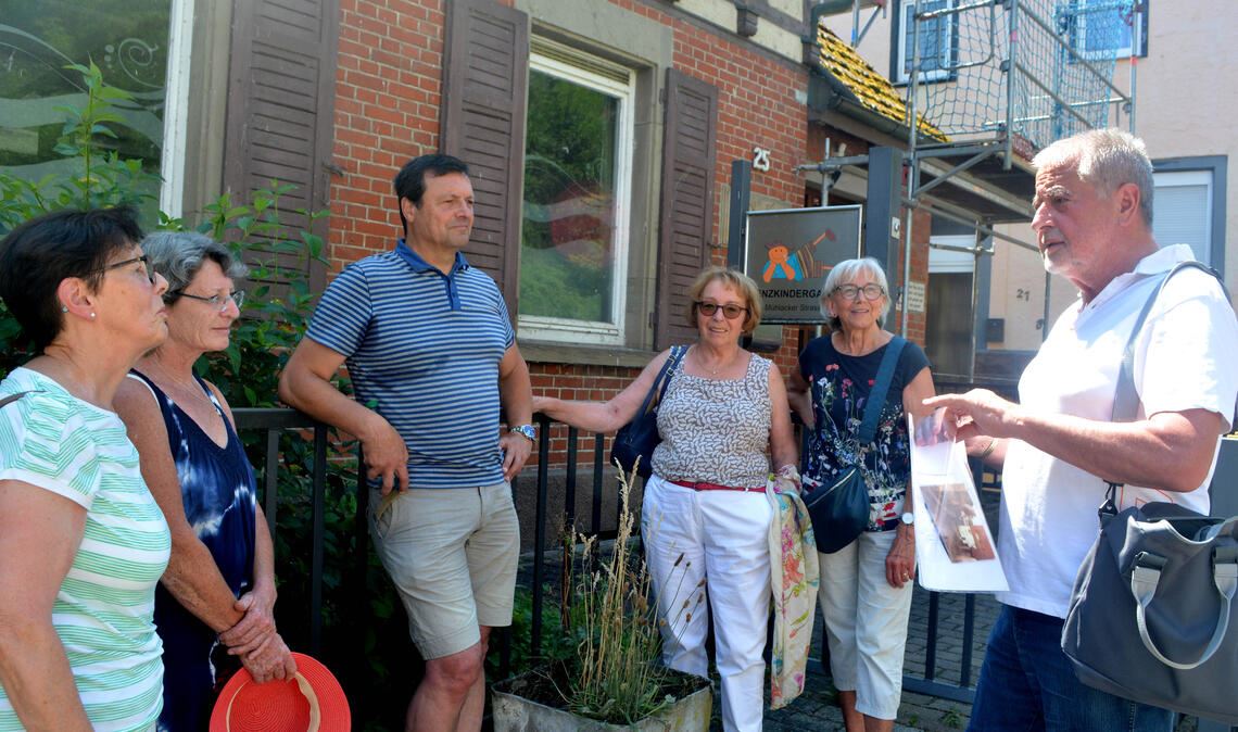 Rudi Lang (re.) rückt bei seiner Stadtführung durch Lomersheim vor allem das Leben der Kinder in der Nachkriegszeit in den Blickpunkt. Foto: Stahlfeld