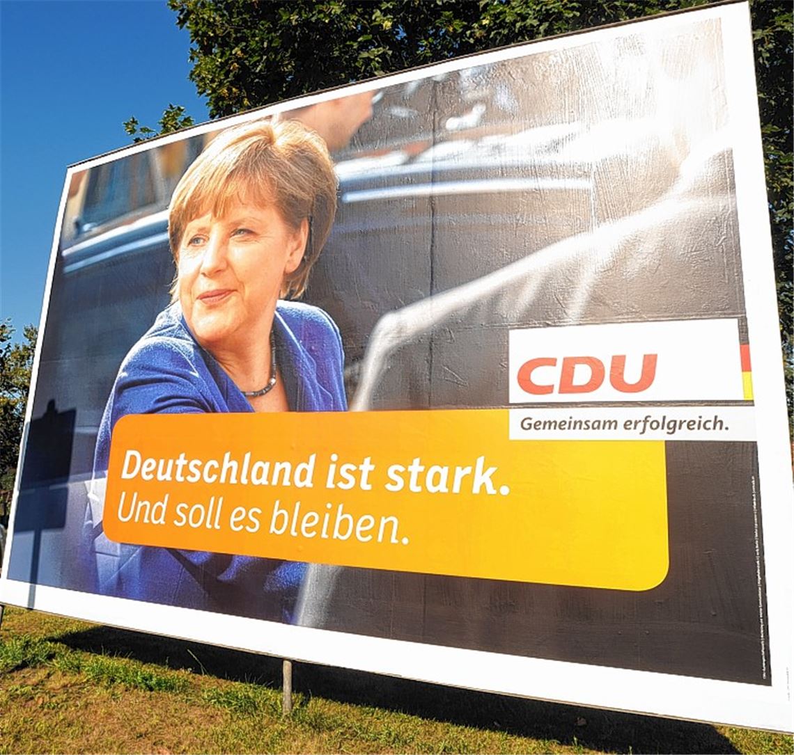 Rücken an Rücken: Am Ortseingang von Ötisheim begrüßt die Kanzlerin das Wahlvolk, während in entgegengesetzter Fahrtrichtung Kontrahent Steinbrück einen Fingerzeig gibt.