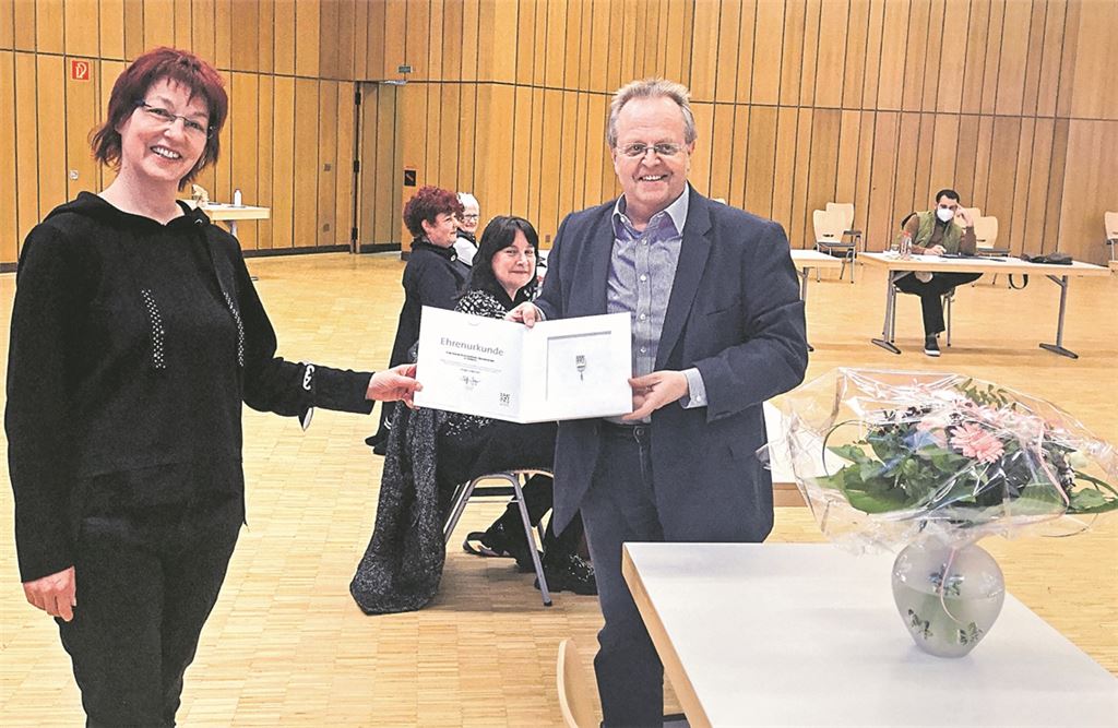 Sabine Bürkhard-Dürr freut sich über die Auszeichnung des Gemeindetags, die ihr Bürgermeister Werner samt einem Blumenstrauß überreicht. Foto: Goertz