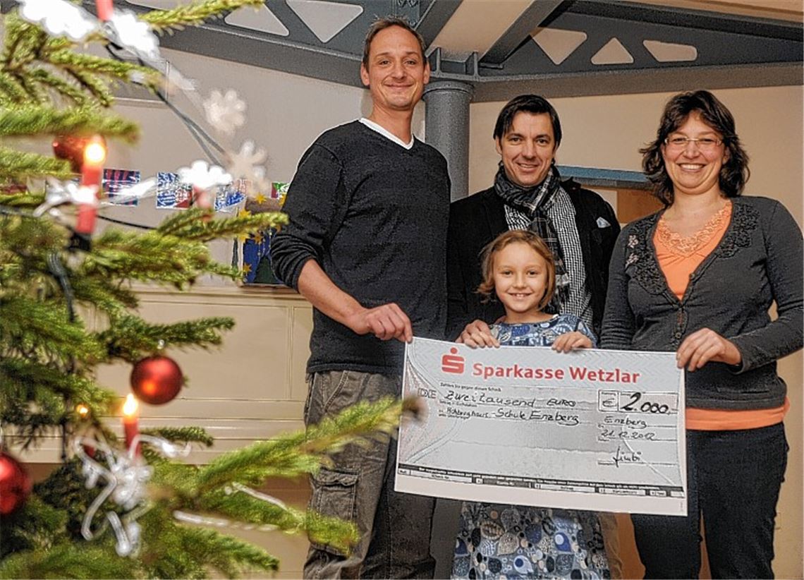 Sabrina Könne und Volker Weber (li.) erhalten von Markus Limberger von der Firma Leica eine Spende von 2000 Euro, die dessen Tochter Chiara überreicht.