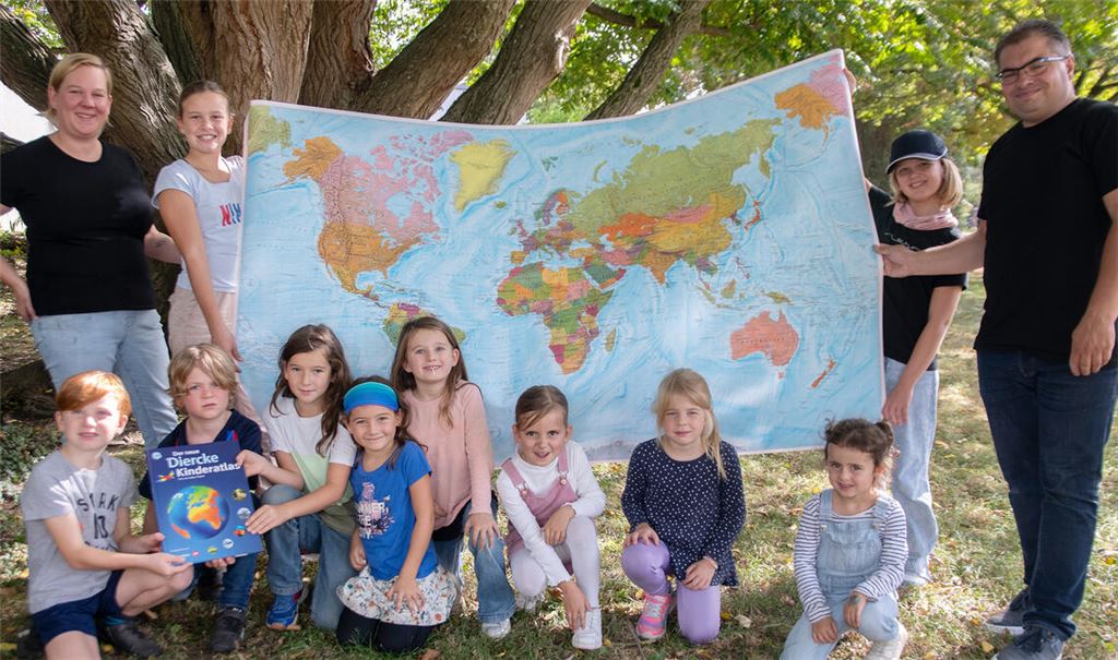 Sarah Elsäßer und Oliver Höhner übergeben im Rahmen des Kürbisfests als Spende des Fördervereins eine Weltkarte und Atlanten für die Mühlhäuser Grundschule. Foto: Fotomoment