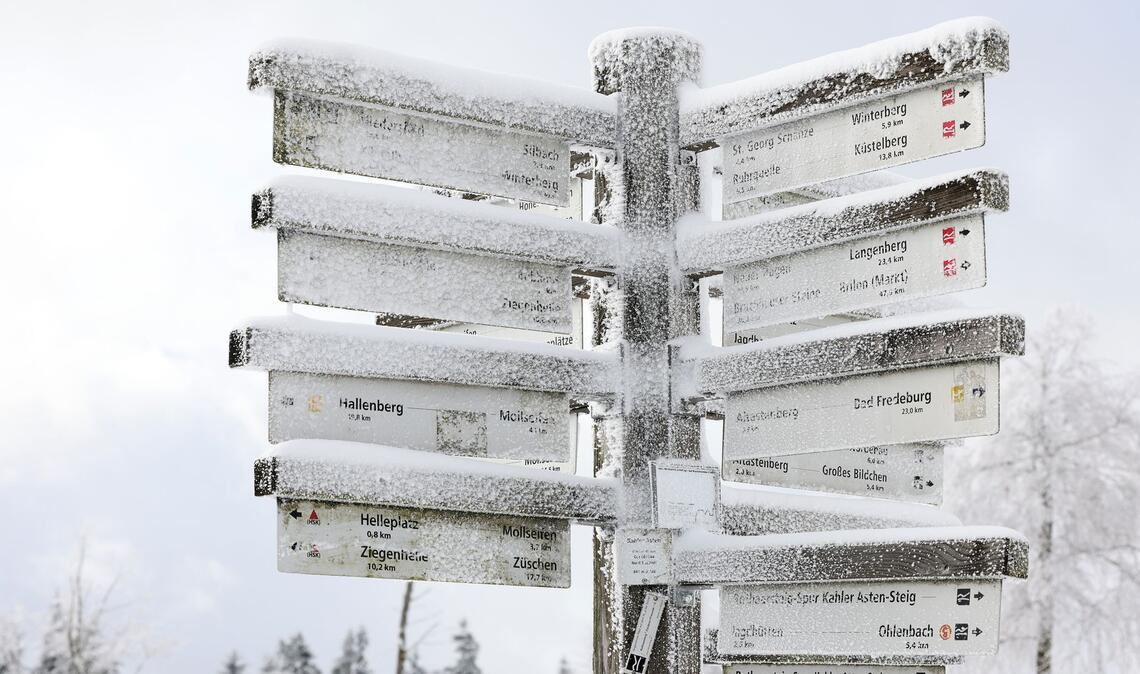 Schnee liegt auf Wegweisern am Kahlen Asten im Sauerland.