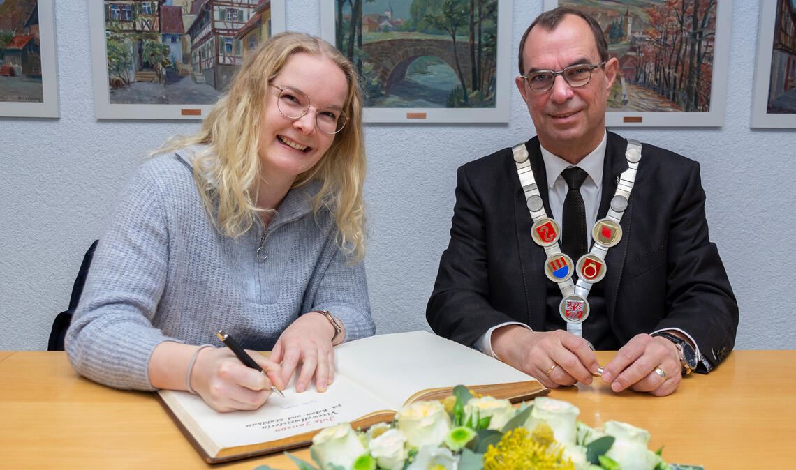 Schon an der Amtskette lässt sich erahnen, dass Oberbürgermeister Frank Schneider einen besonderen Gast empfängt: Jule Janson, die Vize-Weltmeisterin im Beton- und Stahlbetonbau geworden ist, trägt sich in das Goldene Buch der Stadt Mühlacker ein. Foto: Fotomoment