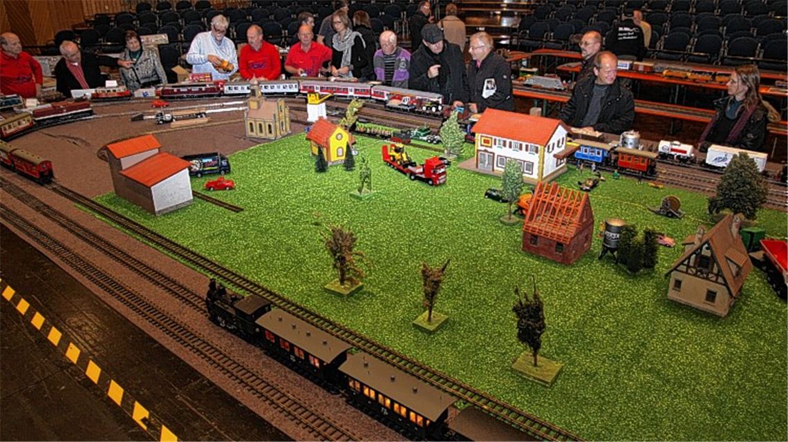 Schon gleich nach der Eröffnung zieht die Eisenbahnschau mit einer Gartenbahn auf der Vorbühne des großen Mühlehof-Saals die ersten Fans unterschiedlichen Alters an. Kleines Bild oben: Heiner Kolmorgen vom Stammtisch des Freundeskreises Siegfried Ade aus Walheim am Flohmarkt-Verkaufsstand. Bild unten: Ernst Vallon aus Schmie präsentiert eine alte Lokomotive.