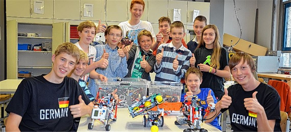Schüler der Roboter AG drücken ihren Mitschülern Alexander Mader (vorne li.) und Andreas Felder (vorne re.) die Daumen für deren Teilnahme an der „World Robot Olympiad“. Foto: Bischoff-Krappel