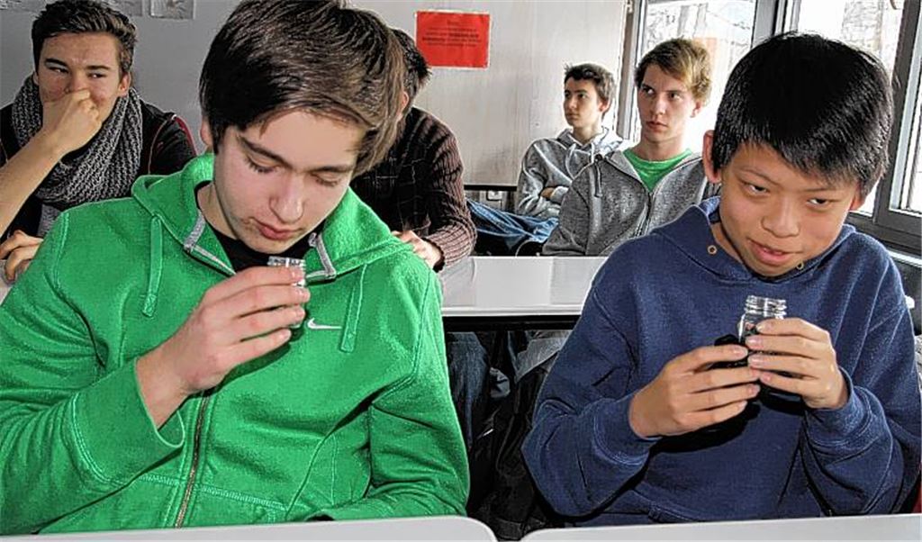 Schüler unterziehen Kunststoff einem Geruchstest.