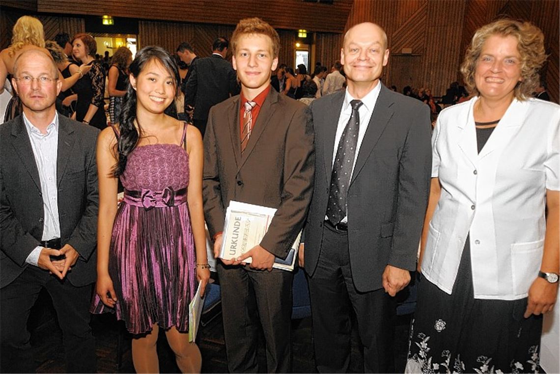 Schulleiter Thomas Mühlbayer (2. v. re.) und seine Stellvertreterin Bärbel König und überreichen Preise an die Jahrgangsbesten Hannes Mondon und Christine Vo. Auch Elternbeiratsvorsitzender Bruno Ziegler gratuliert.