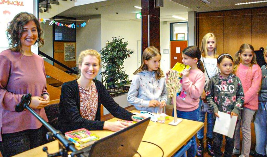 Schulleiterin Theresia Kugele und Autorin Uli Leistenschneider freuen sich über die Begeisterung der Kinder, die ihre mitgebrachten Bücher signieren lassen. Foto: Filitz