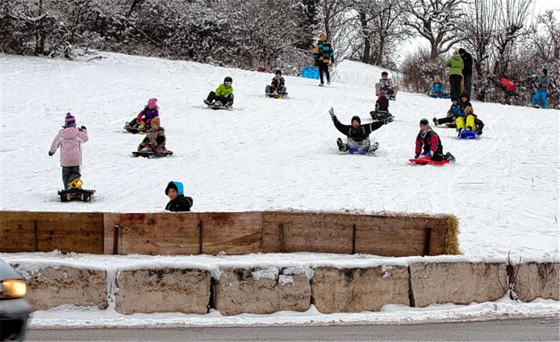 Schutz vor der Straße: Eine Barriere aus Schaltafeln und Strohballen schafft mehr Sicherheit am Schlittenhang.