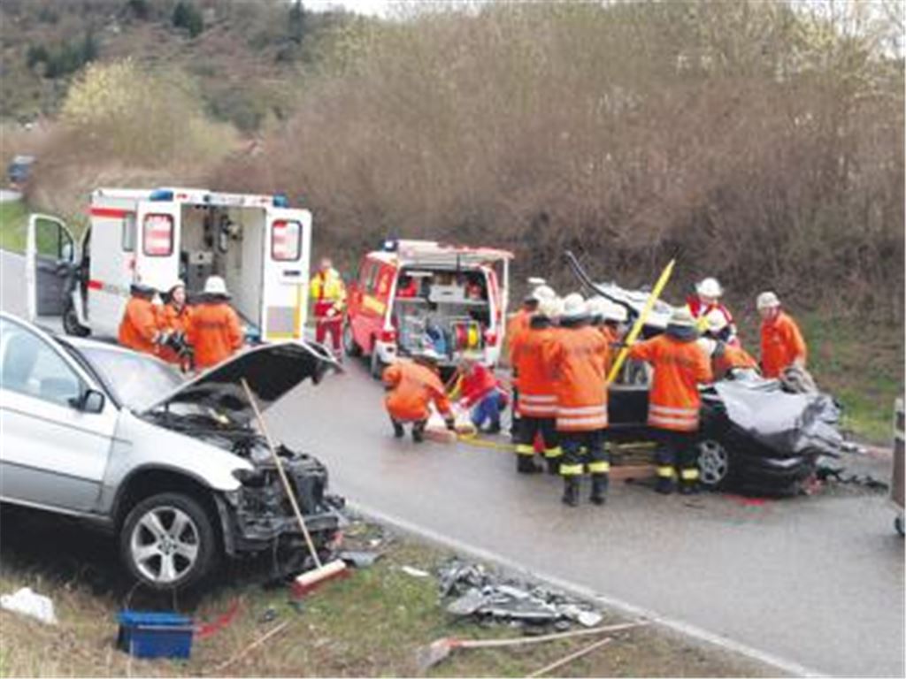 Schwerer Unfall auf der B10: Rettungskräfte bemühen sich um den 23-jährigen Unfallverursacher, der in seinem Wagen eingeklemmt wurde. An der Böschung der beteiligte BMW.Foto: Franz